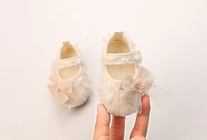 Detail von Baby Mary Jane Lauflernschuhen mit Spitzenblüten und rosa Schleifenakzent