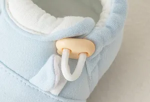 Detail eines hellblauen Baby-Lernlaufschuhs mit verstellbarem Gummiband und weicher Baumwolle