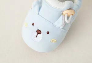 Nahaufnahme der niedlichen Bärenstickerei auf hellblauen, weichen Baby-Lauflernschuhen
