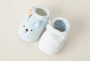 Detail von weichen Baby-Lernlaufschuhen aus Baumwolle mit Bärenstickerei und Verschluss