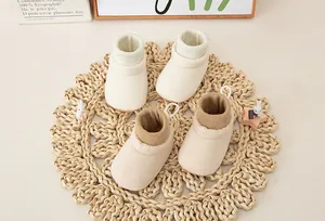 Detail of soft fabric baby walking shoes with ribbed cuffs in cream and light brown