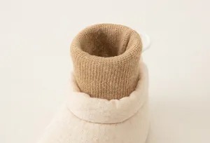 Close-up of ribbed knit cuffs on baby socks shoes with soft cream cotton fabric