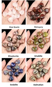 Macro display of six different 15mm heart-shaped natural crystal stones in hand