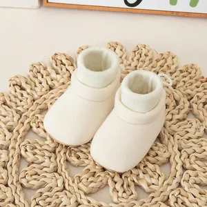 Creamy white baby sock shoes with ribbed cuffs and soft anti-slip soles for toddlers
