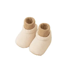Soft-soled baby slip-on shoes with cream fabric and brown ribbed knit ankle cuffs