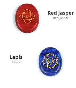 Detail of red jasper and lapis lazuli chakra palm stones with golden engraved symbols