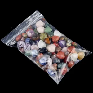 Mixed natural crystal heart stones including rose quartz and amethyst in a clear bag