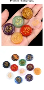 Macro shot of hand holding circular engraved natural agate stones with gold lotus pattern