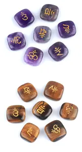 Macro detail of Amethyst and Tiger's Eye healing stones with golden Om symbols engraved