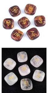 Macro shot of seven chakra amethyst palm stones with golden engraved healing symbols
