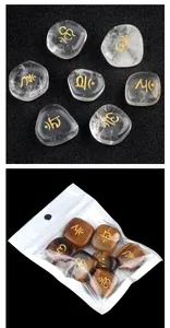 Polished clear quartz and tiger eye chakra stones with golden engraved symbols and packaging