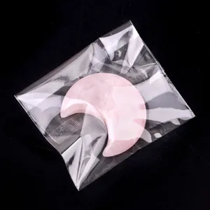 Pierre de cristal en forme de lune en quartz rose naturel avec finition polie sur fond noir