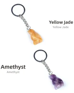 Macro shot of hand-carved penguin keychains made from yellow jade and amethyst gemstone