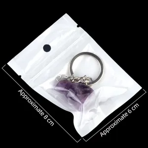 Purple amethyst bird carving keychain with silver ring on minimalist black background