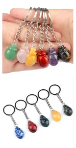 Macro detail of various colorful gemstone beetle keychains with metal rings and chains