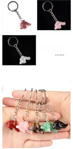 Detail view of colorful dolphin carved gemstone keychains held in hand for size and texture