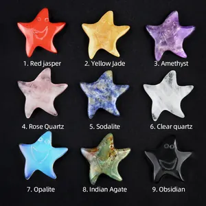 Set of nine natural crystal star-shaped gemstones with carved smiles on black background