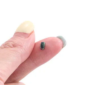 Macro shot of iridescent faceted hematite bead on fingertip for DIY jewelry making