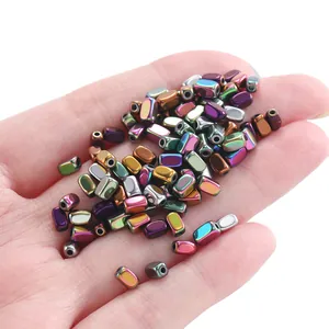Macro view of iridescent hematite faceted rectangle beads held in hand for DIY