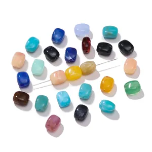Macro view of colorful marble patterned acrylic barrel beads with threading needle for DIY jewelry