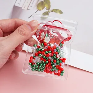 Dettaglio del kit perline fai-da-te con cordino rosso, perle floreali e sfere acriliche