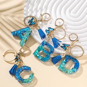 Portachiavi con lettere A-D in resina blu con farfalla glitterata e nappa trendy
