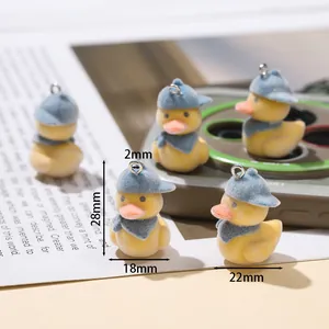 Vue macro de 5 breloques canards jaunes floqués avec chapeaux bleus pour porte-clés DIY