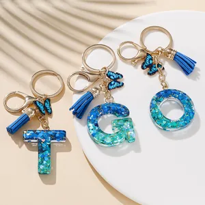 Portachiavi con lettere in resina glitterata blu con farfalla e nappa per borsa donna