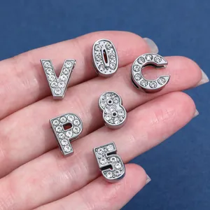 Primo piano di lettere e numeri in lega d'argento con strass scintillanti per artigianato DIY