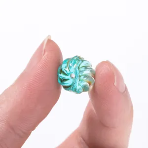 Close-up of a teal spiral watermelon-shaped glass bead for DIY jewelry making