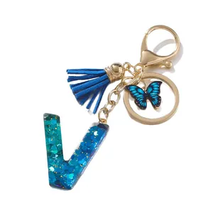 Portachiavi lettera V in resina blu con glitter, farfalla e nappa scamosciata per borsa