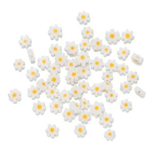 Macro view of white daisy glass beads with yellow centers for DIY jewelry making
