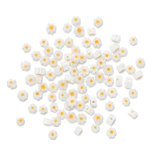 Detailed view of white daisy glass beads with yellow centers for DIY jewelry making