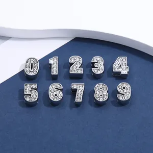 Vista macro di ciondoli numerici 0-9 in lega con strass per creazioni fai-da-te