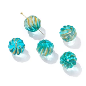 Macro detail of blue glass beads with golden texture and pumpkin spiral for DIY jewelry