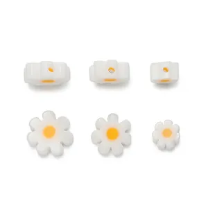 Macro detail of white daisy glass beads showing three sizes and side hole positions