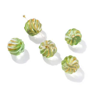 Detail of green and gold iridescent glass pumpkin beads with spiral relief patterns
