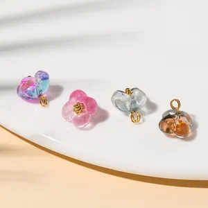 Macro view of transparent glass flower charms with golden cores for DIY jewelry making