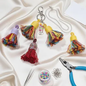 Macro shot of colorful cotton tassels and silver DIY jewelry making components on silk