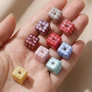 Colorful acrylic checkered square beads held in hand for DIY jewelry making and crafts