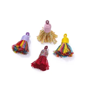 Detailed close-up of four colorful handmade cotton mini tassels for DIY jewelry projects