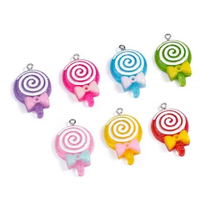 Dettaglio di 7 ciondoli lecca-lecca in resina colorata con motivi a spirale e fiocchetti