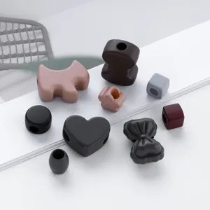 DIY Morandi-colored silicone beads in dog and flower shapes on white steps detail
