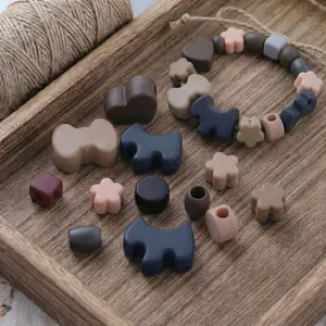 DIY bead set featuring cartoon acrylic shapes in Morandi tones on a rustic wooden tray