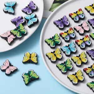 Detalle de coloridos dijes de mariposa de PVC blando para zapatos y manualidades