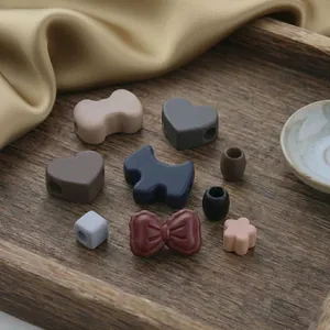 DIY Morandi tone acrylic beads in animal and heart shapes on a vintage wooden tray