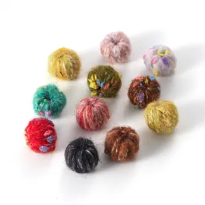 Macro shot of 11 colorful fluffy pom-poms with soft fiber texture for DIY jewelry crafts