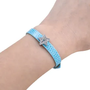 Detail of light blue faux leather snake skin bracelet with a sparkling crystal star charm