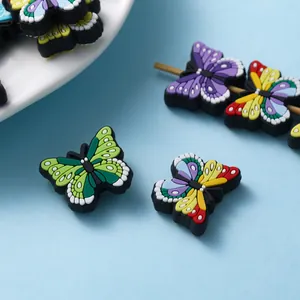 Vista macro de cuentas de mariposa de PVC de colores para hacer collares y dijes DIY