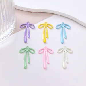 Détails de six breloques nœuds colorées en tons macaron pour la création de bijoux DIY